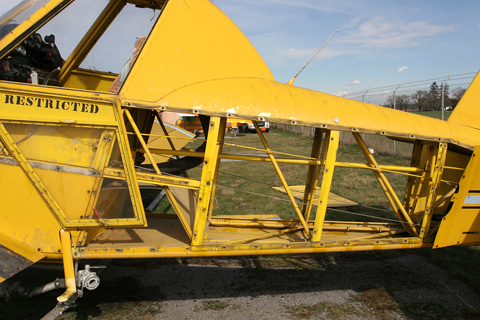 Removing the other side panel adds some clarity to the shot. Easily visible now is the control linkage, linking the control stick and pedals in the cockpit with the rear control surfaces. The rod you can see going through the structure controls the elevator, while the thin gray cables running along the outside of the structure are linked to the rudder