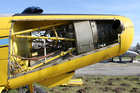 View from a different angle. Again like most turboprops, the PT6 is a free-turbine reverse-flow engine, meaning it's installed ass backwards :). To avoid going into detail, this makes the engine lighter and hence more efficient - and explains why the exhaust pipes are located up front: the back of the engine is thre. Because its front is now deeper in the engine bay, it has to be fed by the air intake visible under the nose