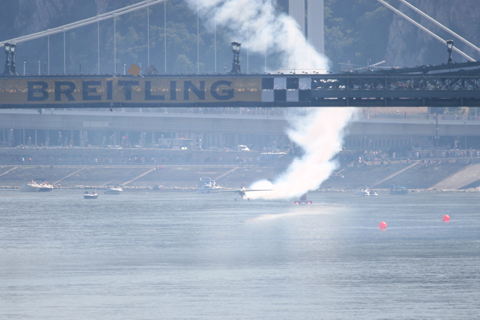 Clipping the wavetops, Yoshihide Muroya, flying Zivko Edge 540 Race Number 31, zips under the Lanchid bridge. With only 10 meters of clearance between the river and the bridge, this is one of the best start gates in the whole race